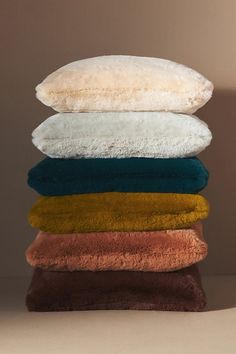 five towels stacked on top of each other in different colors and sizes, with one folded down