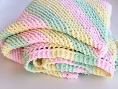 a stack of multicolored crocheted dishcloths stacked on top of each other