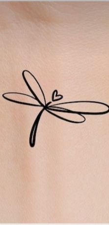 the back of a woman's stomach with a dragonfly tattoo on her chest