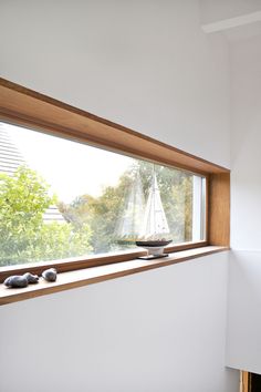 there is a small sailboat on the window sill in this room with rocks