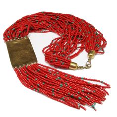 *Description: Bohemian beautiful red Czech seed bead multi-strand tribal fringe necklace with a brass pendant and glass inlay design from the 1970s. The red seed beads have teal blue seed beads scattered throughout the design. The beads are on white thread and have brass end caps. The enamel pendant and fringe are 6 1/2 Inches in length. This would be a great addition to your vintage jewelry collection or make a great vintage gift! *Approximate Measurements: Length - 21 Inches, Pendent Length (w Artisan Red Beaded Necklace With Dangling Beads, Artisan Multi-strand Red Beads, Artisan Red Dangling Beads, Red Multi-strand Dangling Beads, Bohemian Multi-strand Red Beads, Traditional Red Beaded Fringe Jewelry, Red Multi-strand Beads For Festival, Inlay Design, Bead Fringe