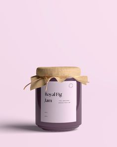 a jar of lavender jam with a wooden lid on a pink background the jar has a label that says royal big jam