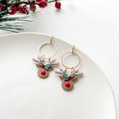 a pair of reindeer earrings on top of a white plate