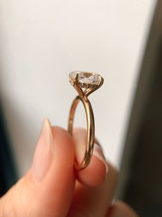 a person holding a ring with a diamond in it