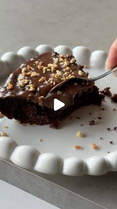 a person cutting into a piece of chocolate cake