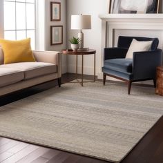 a living room with two couches and a rug on the floor in front of a fireplace