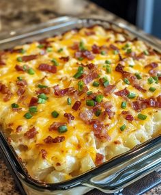 a casserole dish with bacon, cheese and green onions in it on a kitchen counter