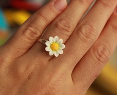 a person's hand with a ring on it and a flower in the middle