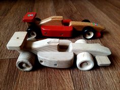 a wooden toy car sitting on top of a hard wood floor next to other toys