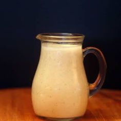 a glass pitcher filled with liquid sitting on top of a wooden table next to the words champagne vinaigrette