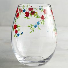 a clear glass with flowers painted on it