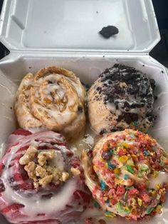 an open take out box filled with different types of donuts