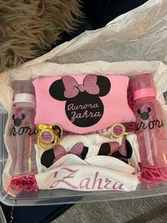 a pink and black minnie mouse diaper set in a plastic container with personalized items