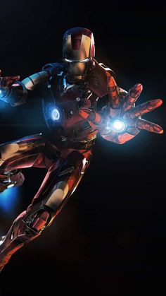 an iron man flying through the air with his hands out and glowing in front of him