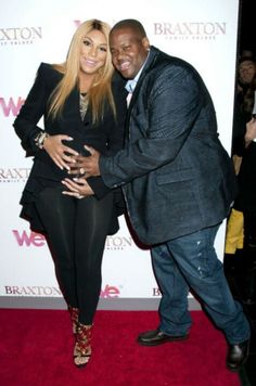 a man standing next to a woman on a red carpet