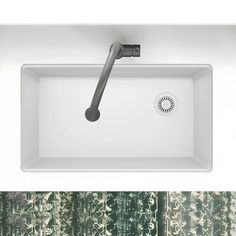 a white sink sitting under a faucet next to a green wallpapered bathroom