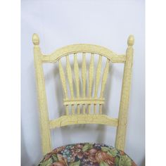 a wooden chair with a floral seat pad on it's back and armrests