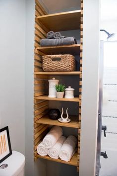 a bathroom with shelving and towels on the shelves next to the toilet is shown