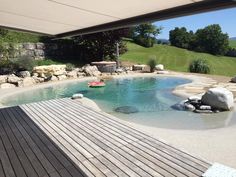 a small pool in the middle of a wooden decked area with rocks and water