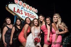 a group of women standing next to each other in front of a las vegas sign