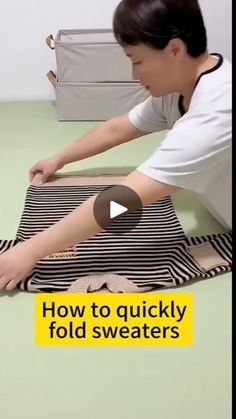 a woman laying on top of a black and white striped blanket next to a bag