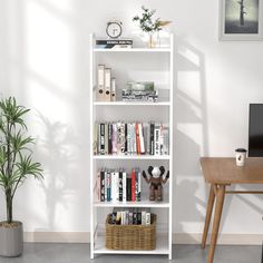 a white book shelf with books, plants and a computer on it next to a potted plant