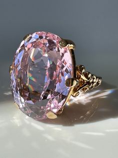 Pretty in Pink! This magnificent Kunzite, weighing a massive 39.9 carats, is perfectly presented in a simple prong setting made of 14k gold with scroll details.  Estimated Gemstone weight 39.9 carats Gemstone dimensions 24.5 x 19.25 x 13.3mm 14k gold Weight 18.2 grams Currently Size 9.25 and easily sizeable Note: the color of Kunzite can fade if exposed to strong sunlight for long periods of time. Mafia Princess, Hand Brooch, Kunzite Ring, Pink Kunzite, Princess Luna, Gold Cocktail Ring, Gold Cocktail, Etsy Gold Ring, Spring Jewelry