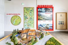 a model of a building with trees and mountains on the wall, in front of a redridge sign