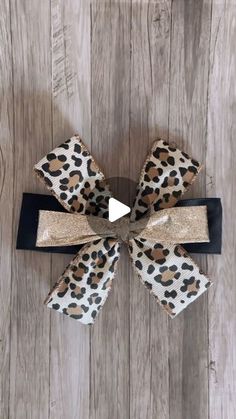 the leopard print hair bow is tied to a wooden wall