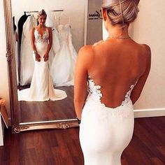 the back of a woman's dress in front of a mirror with her reflection