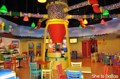 the inside of a children's playroom with colorful chairs and lights hanging from the ceiling