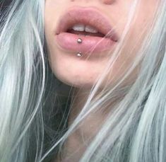 a woman with white hair and piercings on her nose