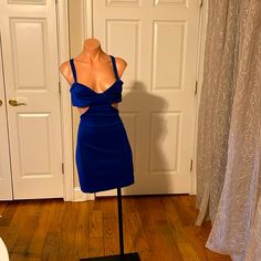 a mannequin wearing a blue dress in front of a door