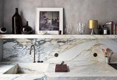 a kitchen with marble counter tops and white sink under a framed photograph on the wall