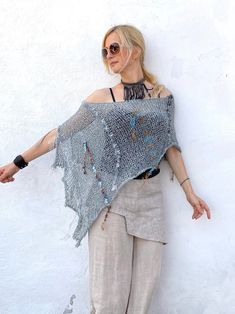 This boho cotton blend hand-knitted fringed poncho in grey and aqua blue tones is light and airy. It is a four-season piece and is ideal for layering  The color palette is definitely jeans friendly.  STYLE This dressy/casual piece is an excellent travel companion.  Works well with jeans, leggings, swimsuit or over a solid dress adding a flowy elegance of a shawl. Endless in its versatility and fits most sizes make it a great gift idea. Material: Cotton Blend WAYS TO WEAR SEE FAQ's FOR WAYS TO WE Bohemian Knit Poncho With Fringe, Bohemian One Size Knit Shawl, Bohemian One-size Knit Shawl, Bohemian Knit Shawl One Size, Bohemian Knit Shawl, Bohemian Knit Poncho, Bohemian Open Knit Beach Poncho, Bohemian Open Knit Poncho For Beach, Bohemian Knitted Shawl For Beach