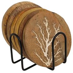 four wooden coasters are stacked on black metal racks with white branches painted on them