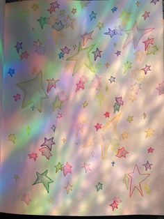 a sheet of paper with stars drawn on it in rainbow colors and white, blue, pink, green, yellow