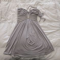 a gray dress laying on top of a bed