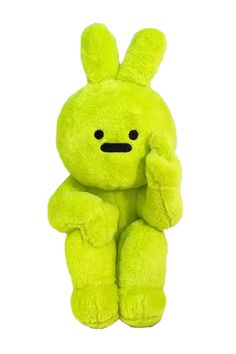 a green stuffed animal with an angry look on it's face and hands in his ears