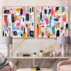 two paintings on the wall in a living room with pink chairs and a coffee table