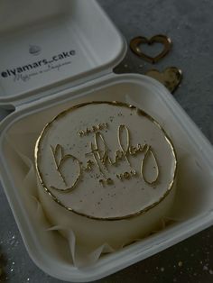 a cake in a container with the word happy birthday written on it