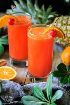 two glasses filled with orange juice and garnished with cherries