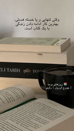 two books and a coffee cup on a table with an arabic quote in the background