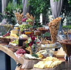 a table filled with lots of different types of cheeses and crackers on it