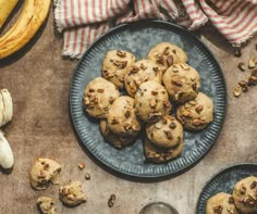 chocolate chip cookies on a plate next to bananas and other food items, including banana peels