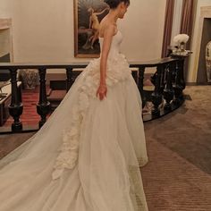 a woman in a wedding dress is standing on the stairs