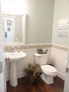 a white toilet sitting in a bathroom next to a sink and mirror with words above it