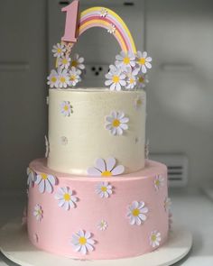 a pink and white cake with flowers on it