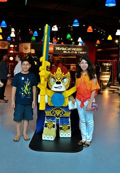 two girls standing next to a lego character