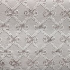 an upholstered white fabric with silver swirls